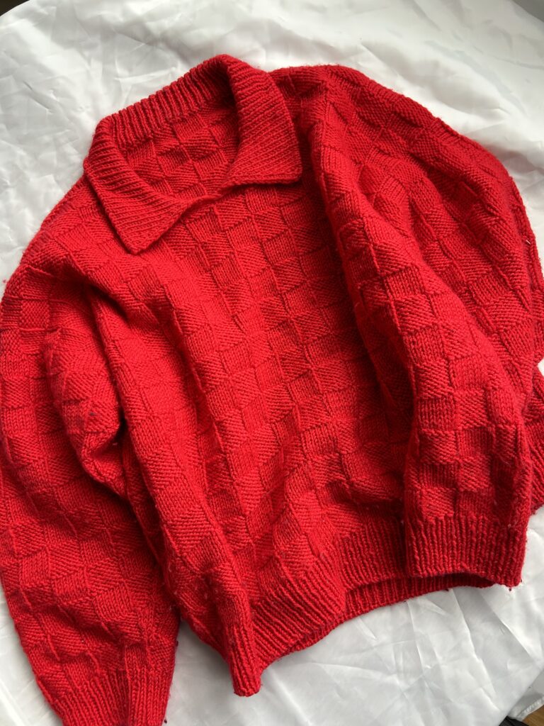 basket weave sweater flatlay picture, red version of thhis knitting pattern