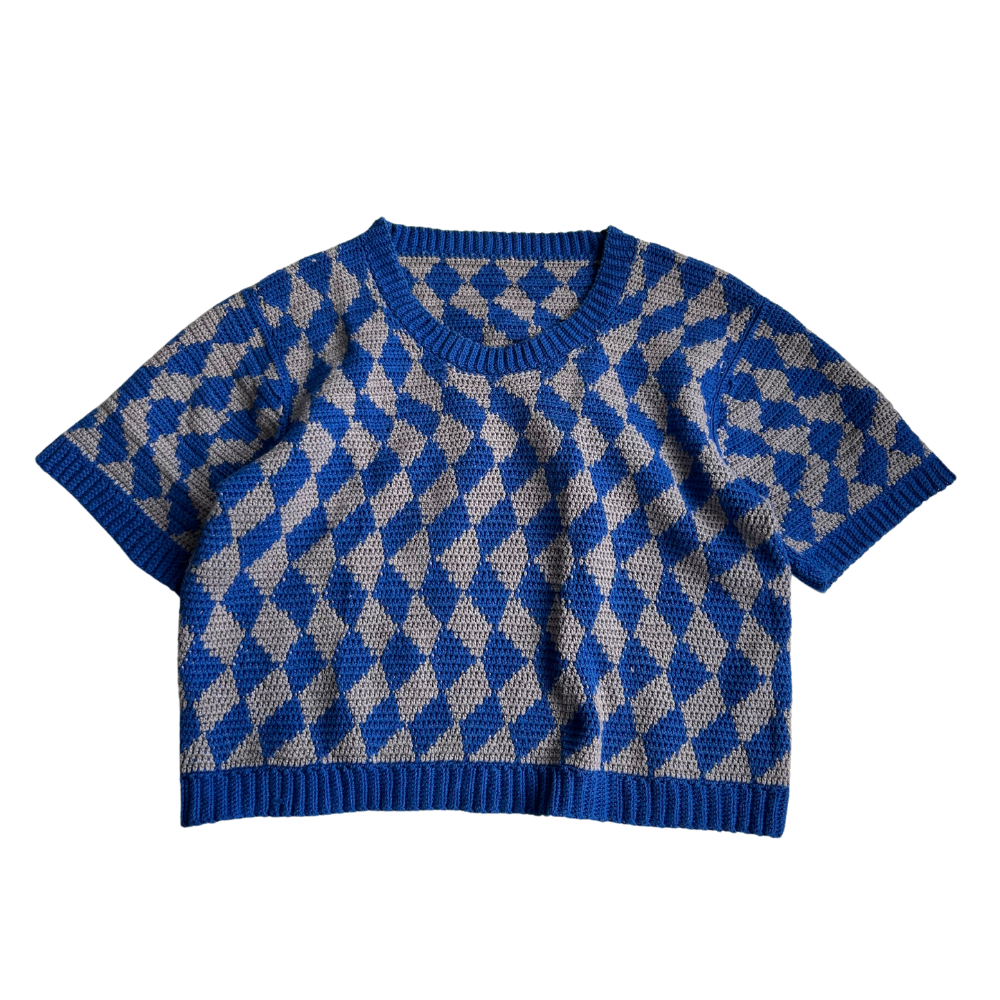 Flatlay of the trippy Tee Crochet Pattern. This prototype is made in grey and kobalt blue.